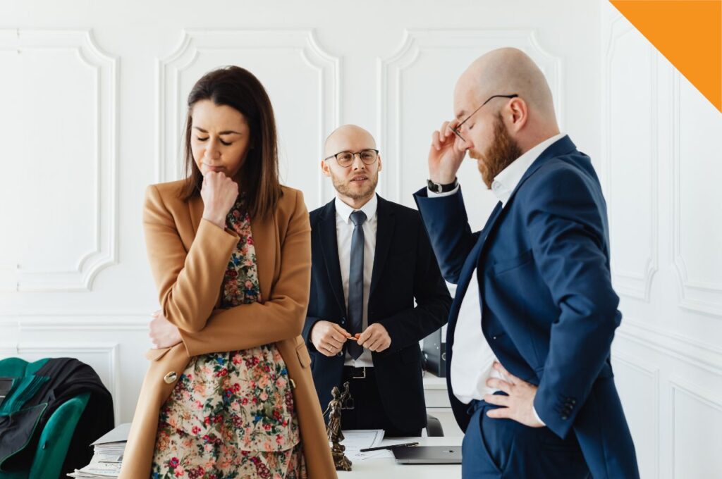 A man and a woman upset with each other and a businessman standing between them.