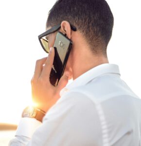 hassan-ouajbir-IYU_YmMRm7s-unsplash man turned away from the camera in white shirt on the phone
