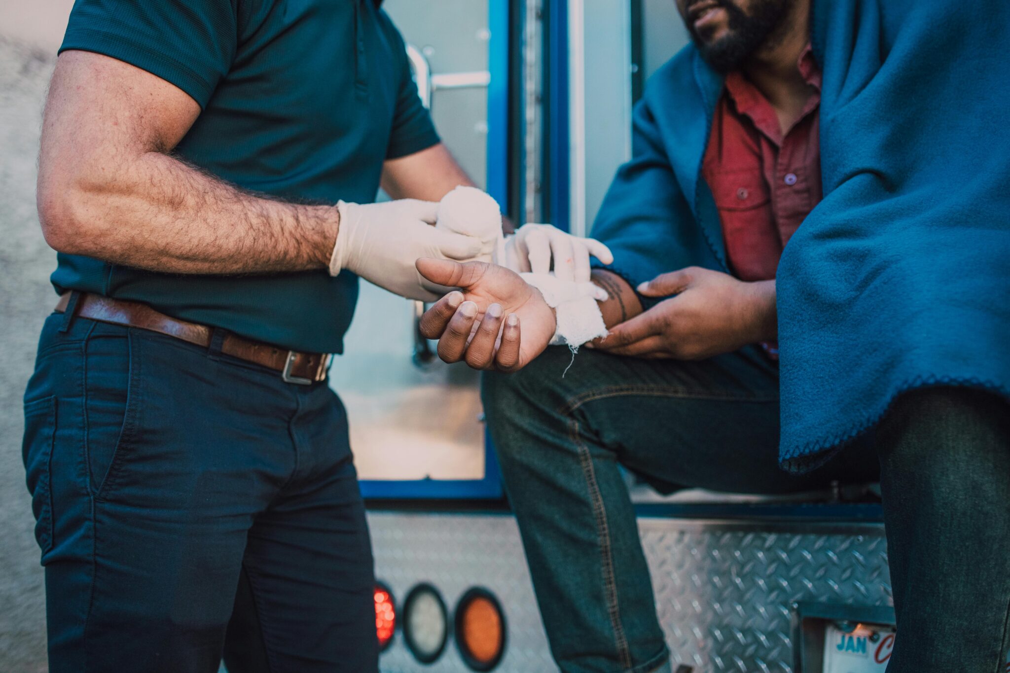 pexels-rdne-6520104 paramedic with gloves on wrapping a car accident victim's hand in gauze