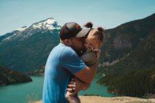 Parent holding child against nature backdrop