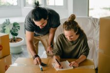 Couple writing on piece of paper in house
